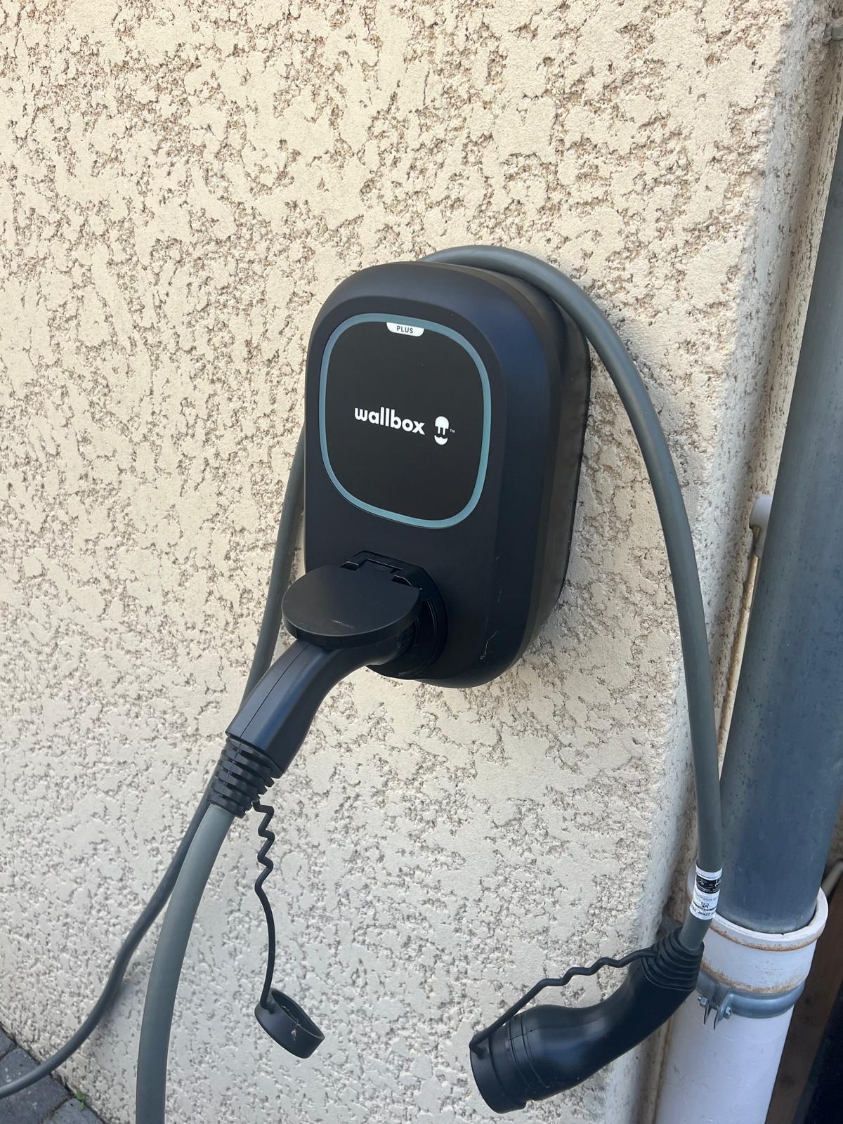 Borne de recharge intelligente Wallbox installée au mur d'une maison